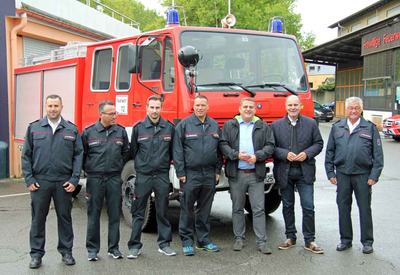 Übergabe des Tanklöschfahrzeugs vor dem Singener Gerätehaus. Sieben Männer vor einem Tanklöschfahrzeug.