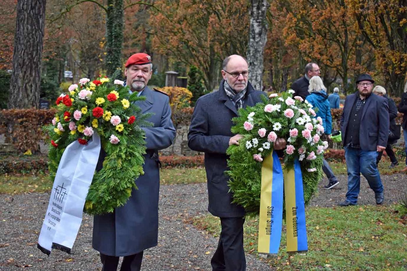 Zwei Männer mit Kränzen in den Händen