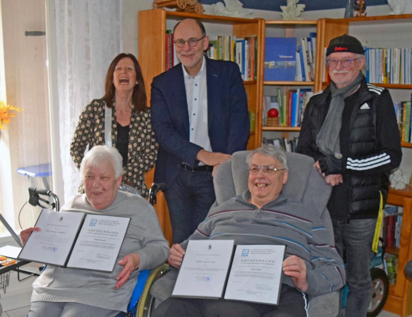 5 Personen, 2 sitzen und 3 stehen 