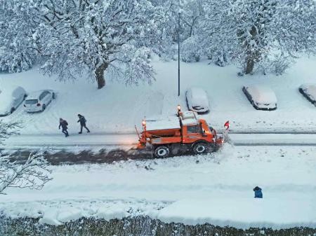 Ein Schneefahrzeug räumt eine Straße.